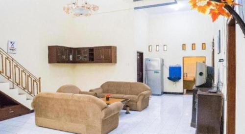 a living room with two couches and a refrigerator at OYO 643 Al Thalib 8 Syariah in Malang