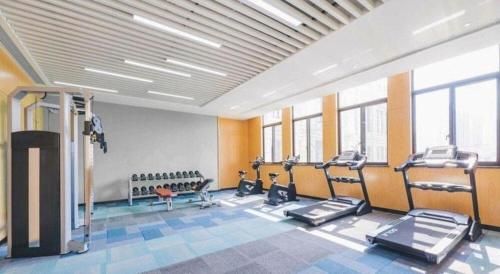 a gym with several treadmills and machines in a room at Atour Hotel Weihai Shidao in Dongshan