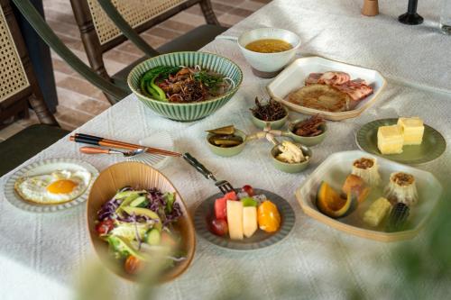 a table with plates of food and bowls of food at 大理空山语 风眠艺术海景酒店 Dali Kongshanyu Art Seaview Hotel in Dali Airport