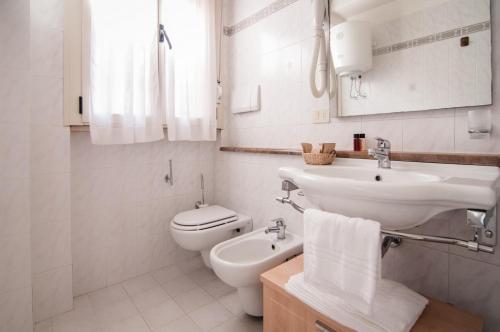 biała łazienka z umywalką i toaletą w obiekcie Residence La Rosa di Nettuno w mieście Marina di Grosseto