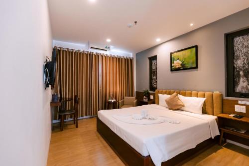 a bedroom with a large bed in a room at Gardenia Hue Hotel in Hue