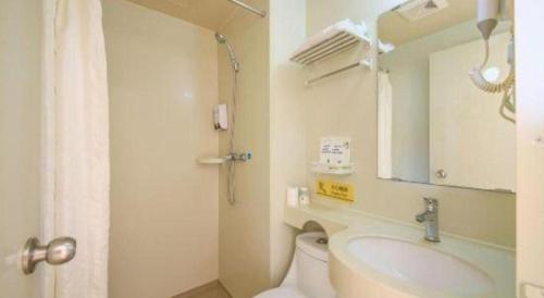 a bathroom with a toilet and a sink and a mirror at 7 Days Inn·Ulanqab Tsining railway station in Ulanqab