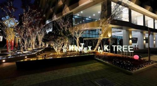 a building with a christmas tree in front of it at Kintex by K-tree in Goyang