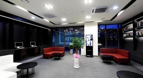 a waiting room with red chairs and tables at Kintex by K-tree in Goyang