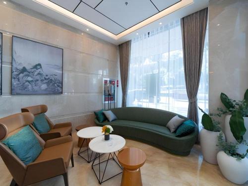 a living room with a green couch and chairs at GreenTree Eastern Dali Railway Station Hotel in Dali