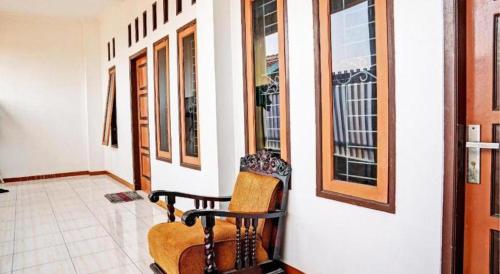 a room with a chair on the side of a building at Hotel O Penginapan Hj Lilis 2 Syariah in Sukabumi