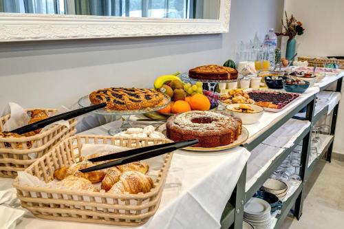 Un buffet con muchos tipos diferentes de pan y pasteles. en Palazzo Belvedere Chianciano Terme, en Chianciano Terme