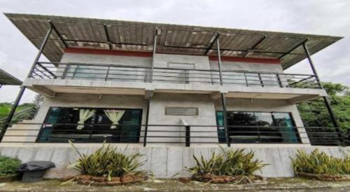 a house with a balcony and some plants at OYO 1167 Ban Pa Rim Khuean in Nakhon Nayok
