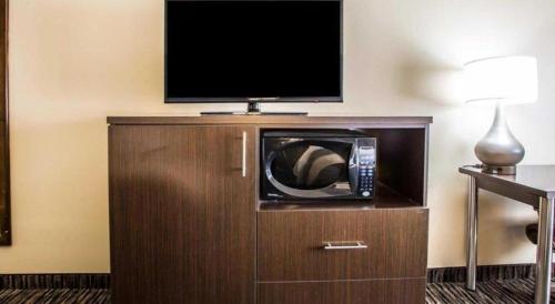 a hotel room with a microwave and a flat screen tv at Quality Inn Dayton North - Vandalia in Dayton