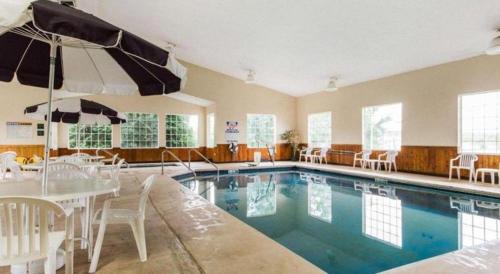 a swimming pool with a table and chairs and an umbrella at Quality Inn in Edgerton
