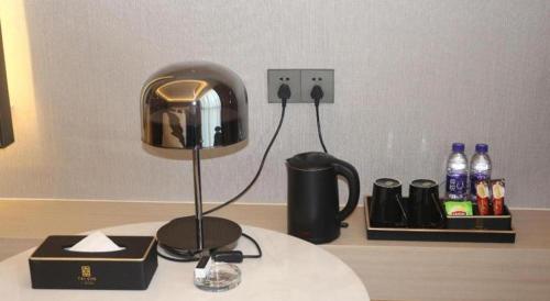 a desk with a lamp and a cup on a table at Taiyi International Hotel in Wenzhou