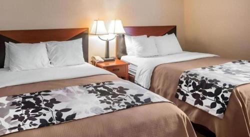 a hotel room with two beds and a phone at Rodeway Inn & Suites Salina South in Salina