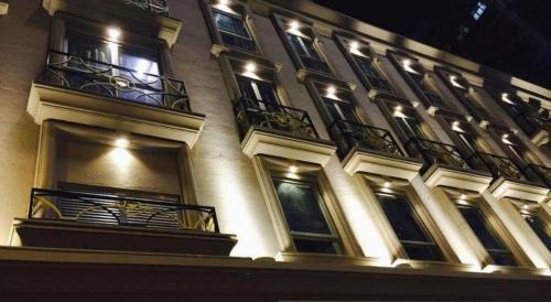 a building with balconies and lights on it at night at King's Hotel in Hong Kong