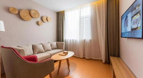 a living room with a couch and a table at New Beacon Sunyee SPA Hotel in Wuhan