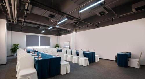 a conference room with blue tables and white chairs at New Beacon Sunyee SPA Hotel in Wuhan