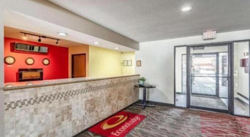 a bar in a restaurant with a red wall at Econo Lodge Ithaca Airport in Ithaca