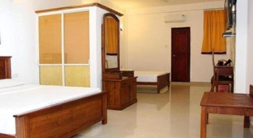 a large room with a bed and a mirror at OYO 246 Roy Villa Beach Hotel in Beruwala