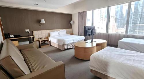 a hotel room with two beds and a television at H1 Hotel in Hong Kong