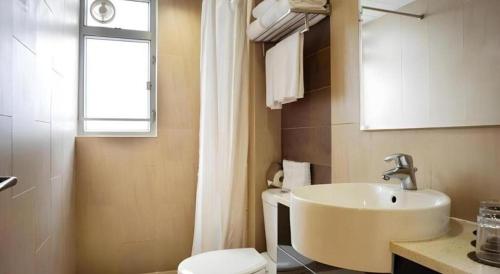 a bathroom with a sink and a toilet and a window at H1 Hotel in Hong Kong