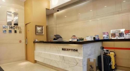 a hotel lobby with a reception counter and luggage at H1 Hotel in Hong Kong