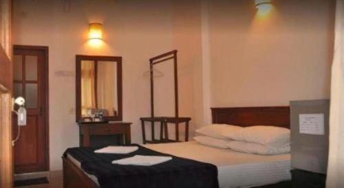a bedroom with a bed with towels on it at Dads Holiday Home in Matale