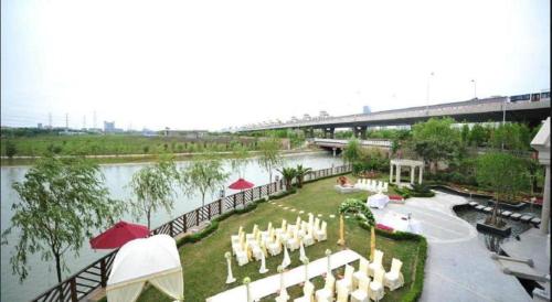 a banquet area with white tables and chairs next to a river at New Century Manju Hotel Shanghai New International Expo Center in Shanghai
