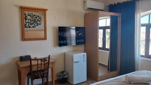 a room with a refrigerator and a table and a window at Moab Land Hotel in Madaba