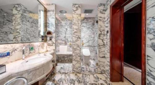 a bathroom with a tub and a sink and a mirror at Northwest Petroleum Hotel in Ürümqi