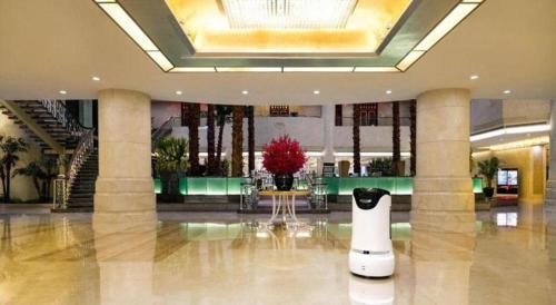 a lobby with a vase in the middle of a building at Northwest Petroleum Hotel in Ürümqi