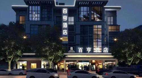 a large building with cars parked in front of it at Yiwu Baiheng Hotel in Yiwu