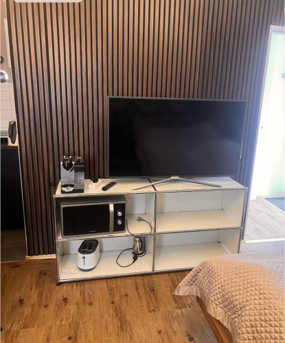 een entertainmentcentrum met een televisie en een magnetron bij Urban Art Studio Köln City in Keulen