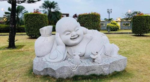 a statue of a woman with two kittens in a park at The BCC Hotel & Residence in Nagoya