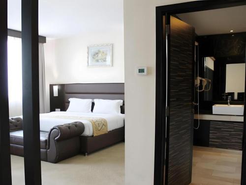 a bedroom with a bed and a bathroom with a sink at The BCC Hotel & Residence in Nagoya