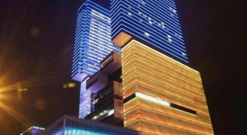 a tall building with blue lights on it at night at StarWorld Hotel in Macau