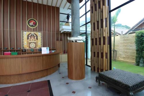 a lobby with a counter and a bench in a building at Phi Phi Nice Beach Hotel Hip in Phi Phi Don