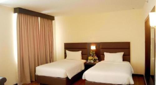 a hotel room with two beds and a window at The BCC Hotel & Residence in Nagoya