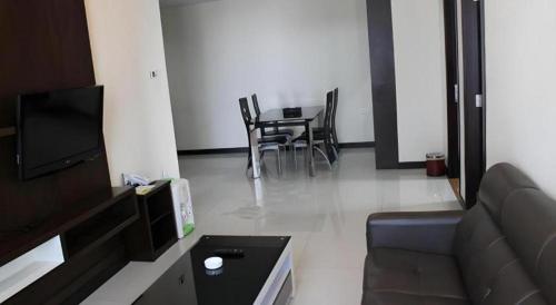a living room with a couch and a table with chairs at The BCC Hotel & Residence in Nagoya