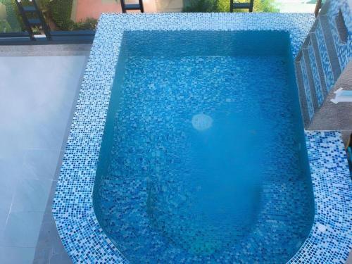 a swimming pool with blue tiles on the ground at Phi Phi Nice Beach Hotel Hip in Phi Phi Don