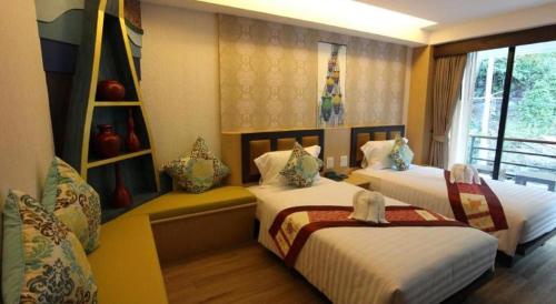 a bedroom with two beds and a window at Phi Phi Nice Beach Hotel Hip in Phi Phi Don