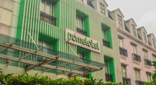a building with a pharmacy sign on the side of it at Pomelotel Patra Kuningan Jakarta in Jakarta