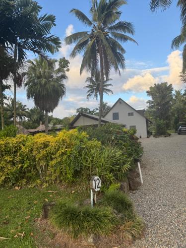 a house with palm trees and a street sign at MIRZ Accomodation in Pacific Harbour