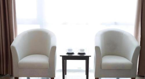 two chairs and a table in a room with a window at Thai An Hotel in Cửa Lò