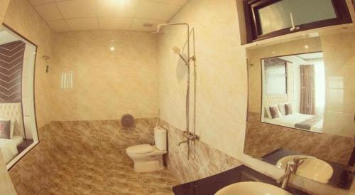 a bathroom with a toilet and a sink and a mirror at Thai An Hotel in Cửa Lò