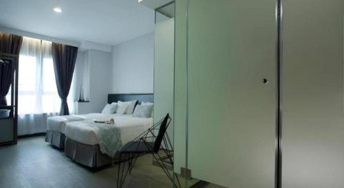 a bedroom with a white bed and a glass door at M1 North Point Hotel in Hong Kong