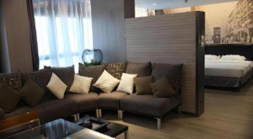a living room with a couch and a bed at M1 North Point Hotel in Hong Kong