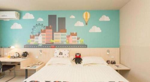 a bedroom with a bed with a city mural on the wall at Jinjiang Inn Changchun Xi An Avenue Branch in Changchun