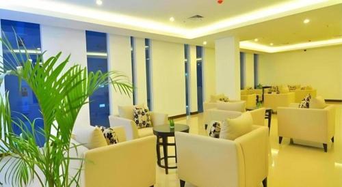 a waiting room with white chairs and a plant at Bogor Valley Hotel in Bogor