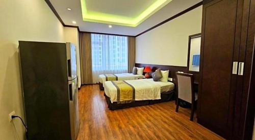 a hotel room with two beds and a television at Lenid Hotel Tho Nhuom in Hanoi