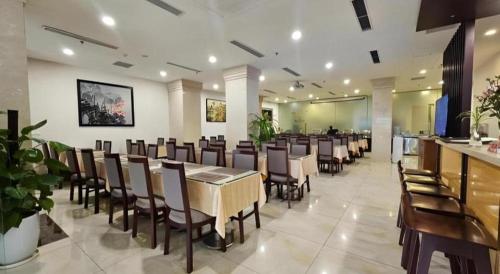 a restaurant with a long dining room with tables and chairs at Lenid Hotel Tho Nhuom in Hanoi