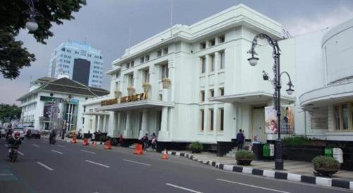 a white building on the side of a street at Raffleshom Hotel in Bandung